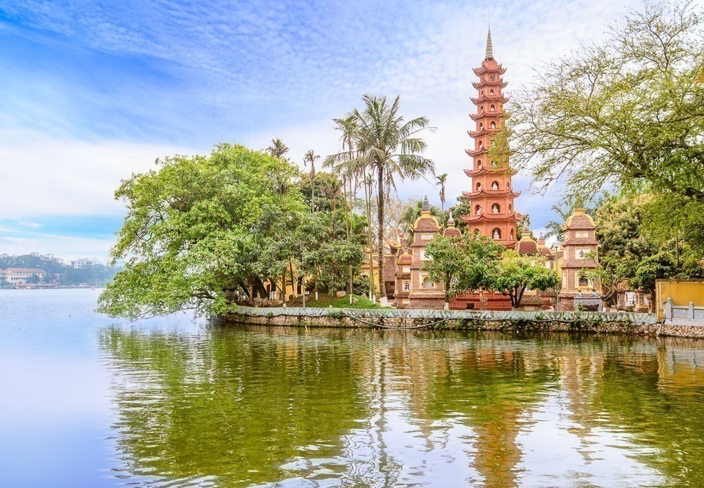 Pagode Tran Quoc refletido na água do lago em um dia claro em Hanói.