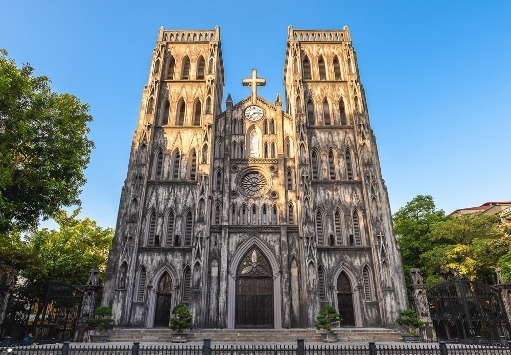 Fachada frontal da Catedral de São José em Hanói iluminada pelo sol.