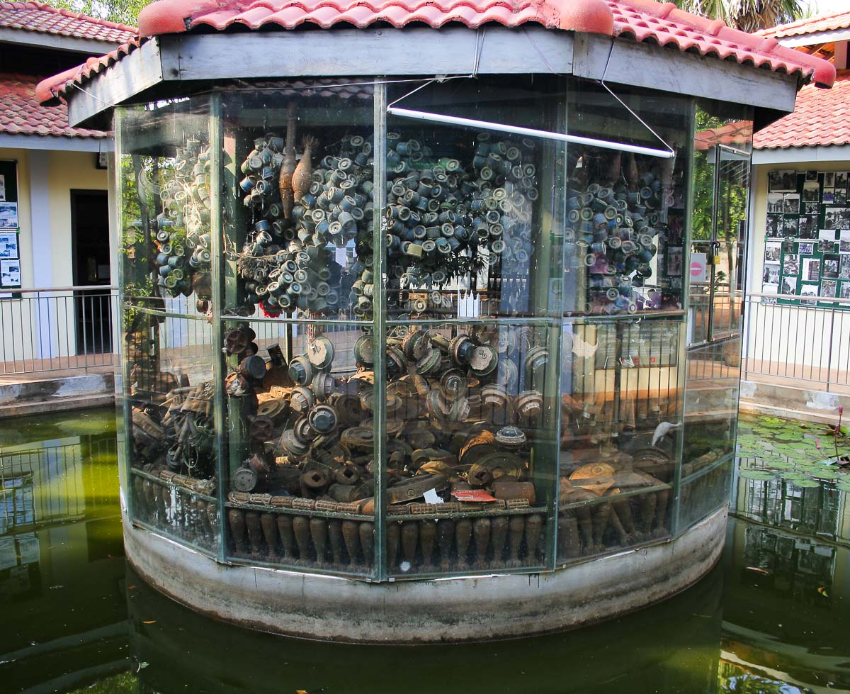 Mostruário de artefatos de minas terrestres em expositor de vidro no museu do Camboja.