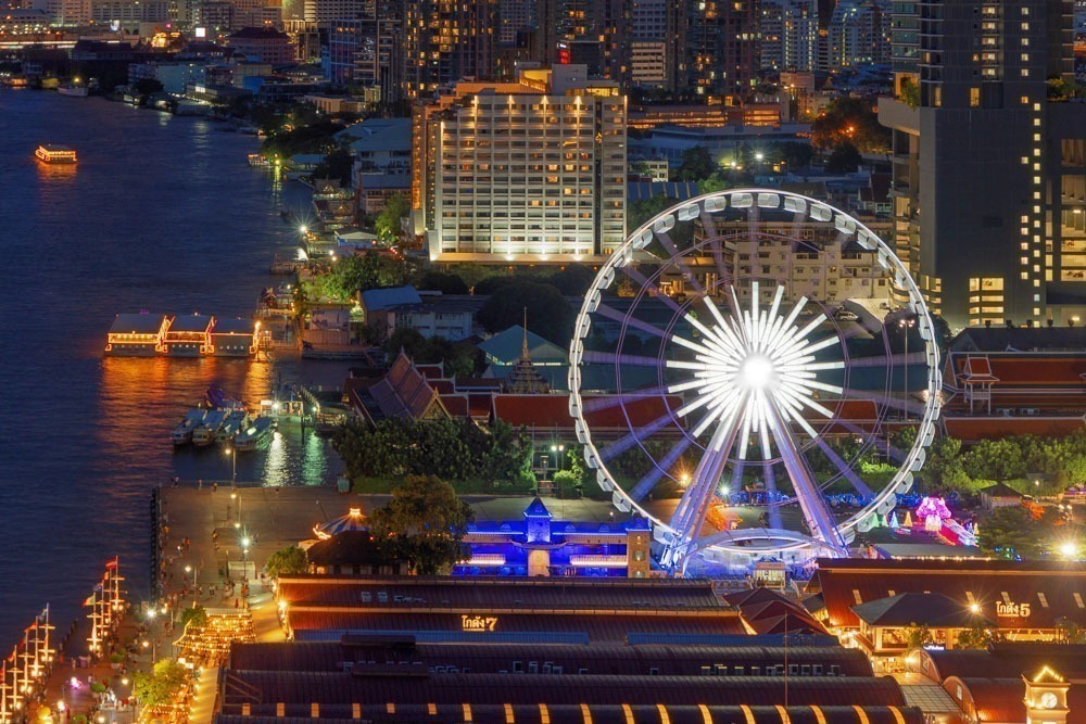 Roda-gigante e píer iluminado do Asiatique The Riverfront, às margens do rio Chao Phraya.