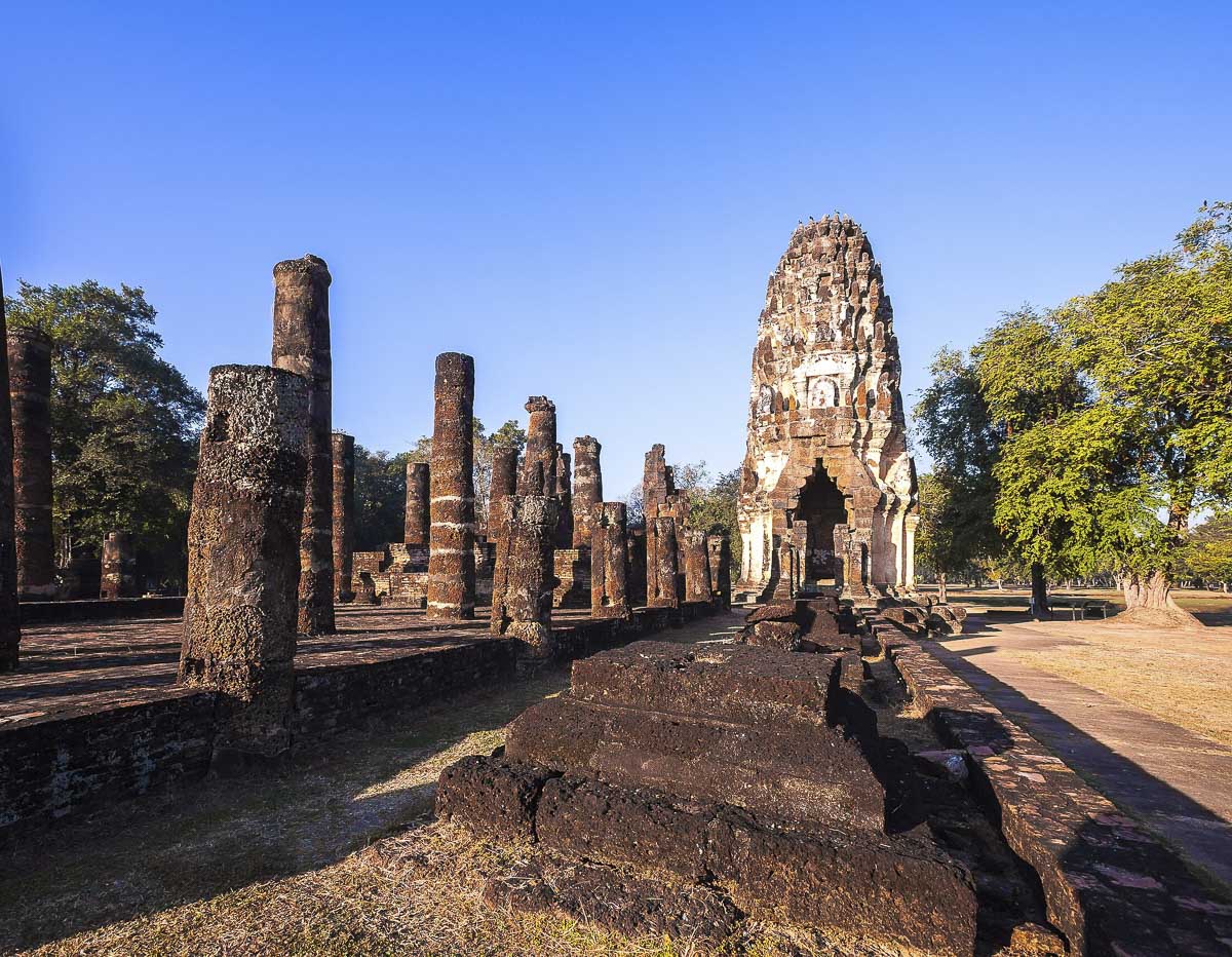 Torre central de pedra cercada por colunas antigas no templo Wat Phra Phai Luang, em Sukhothai.