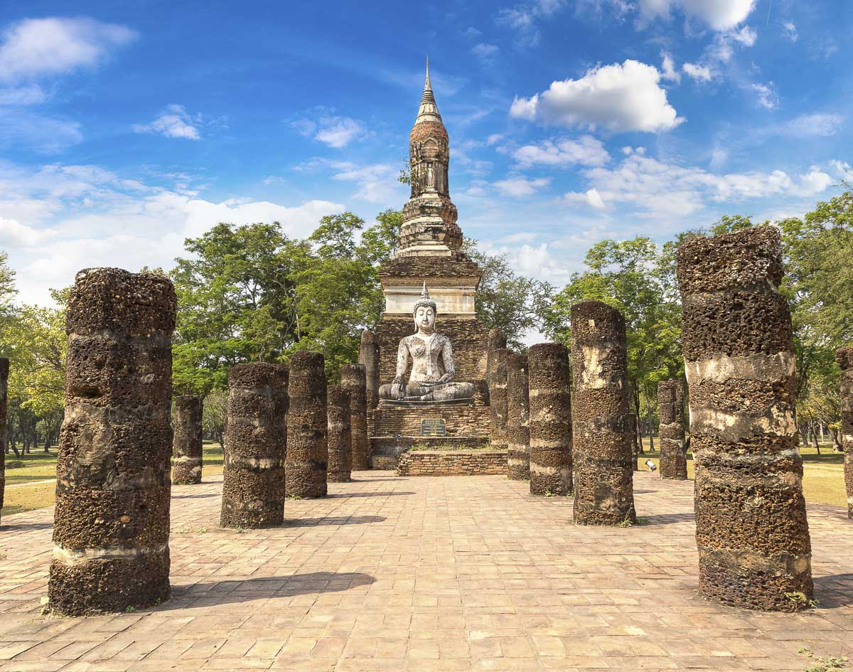Estátua de Buda sentada entre colunas antigas no templo Wat Traphang Ngoen, em Sukhothai.
