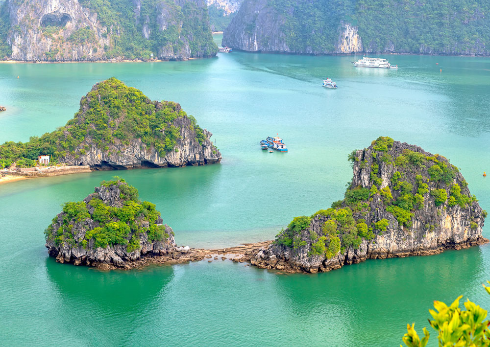 Vista panorâmica da Ti Top Island com ilhotas rochosas cercadas por mar verde-esmeralda em Halong Bay.