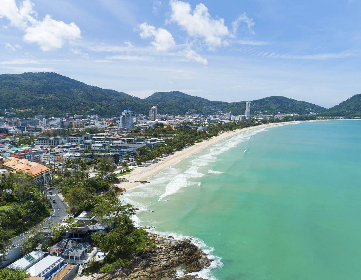 Vista aérea de Patong Beach mostrando a longa faixa de areia e o mar esverdeado de Phuket.