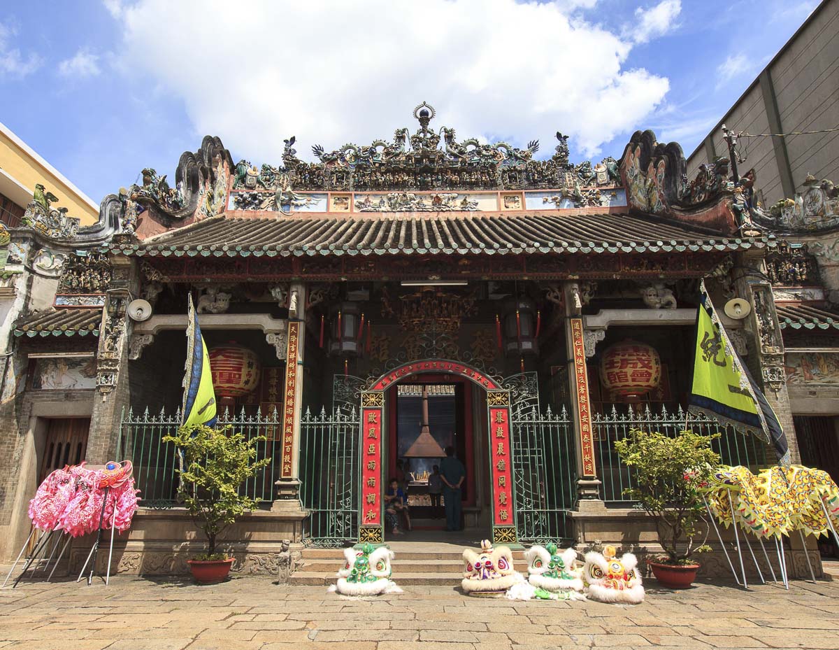 Entrada da Thien Hau Pagoda em Ho Chi Minh, com fachada detalhada, lanternas vermelhas e enfeites usados em apresentações de dança do leão.