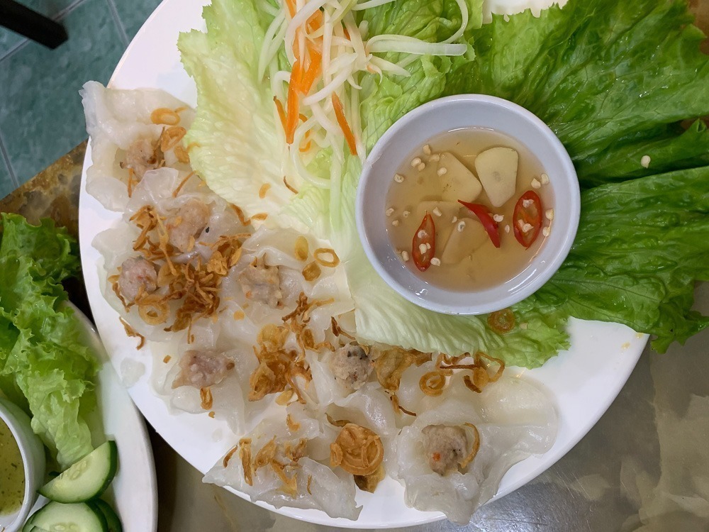Prato de white rose dumplings, iguaria típica de Hoi An, servido com molho e vegetais frescos.