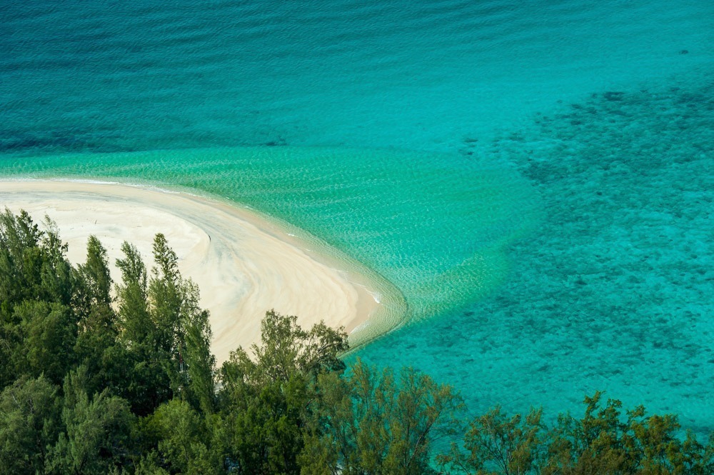 Encontro de faixa de areia curva com o mar azul-turquesa em Koh Lipe.