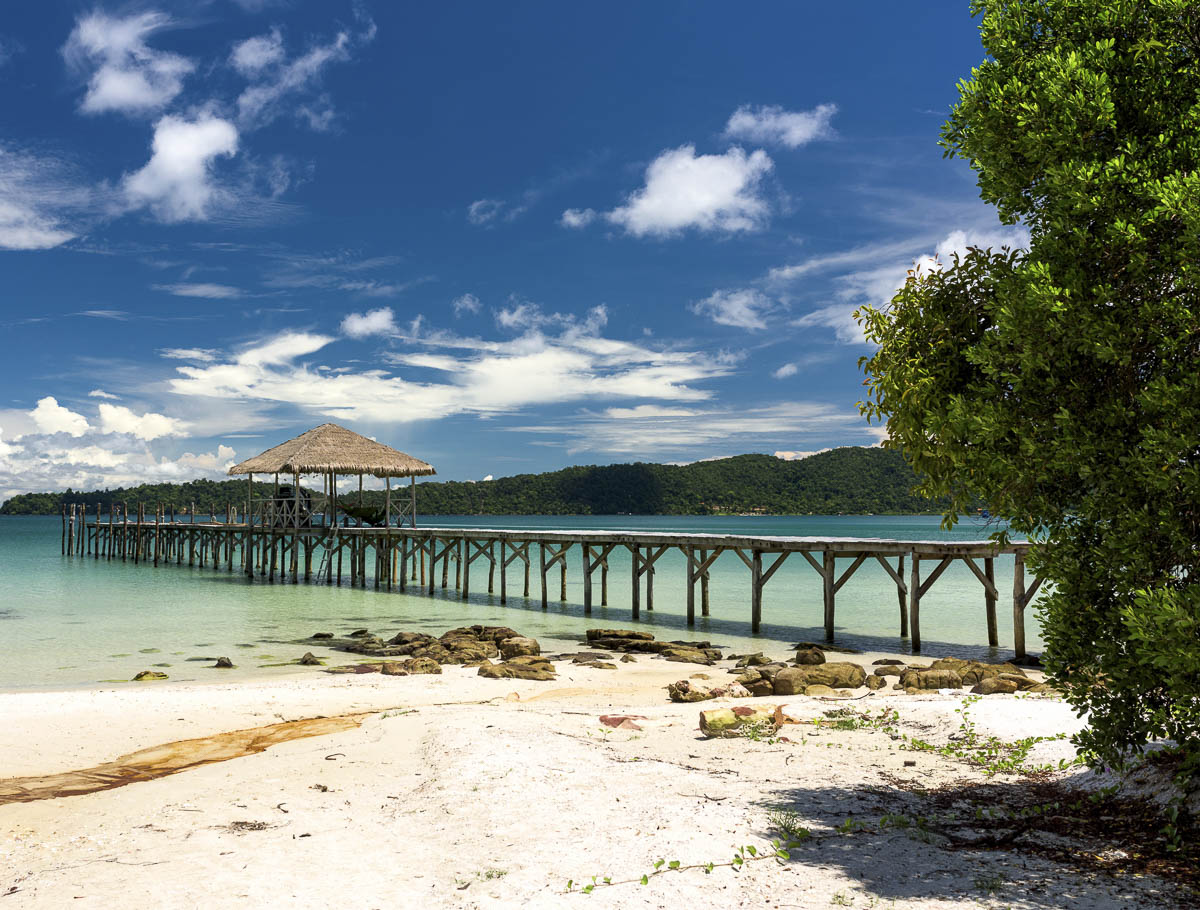 Píer de madeira com quiosque sobre o mar azul-claro em Saracen Bay, Koh Rong Sanloem.