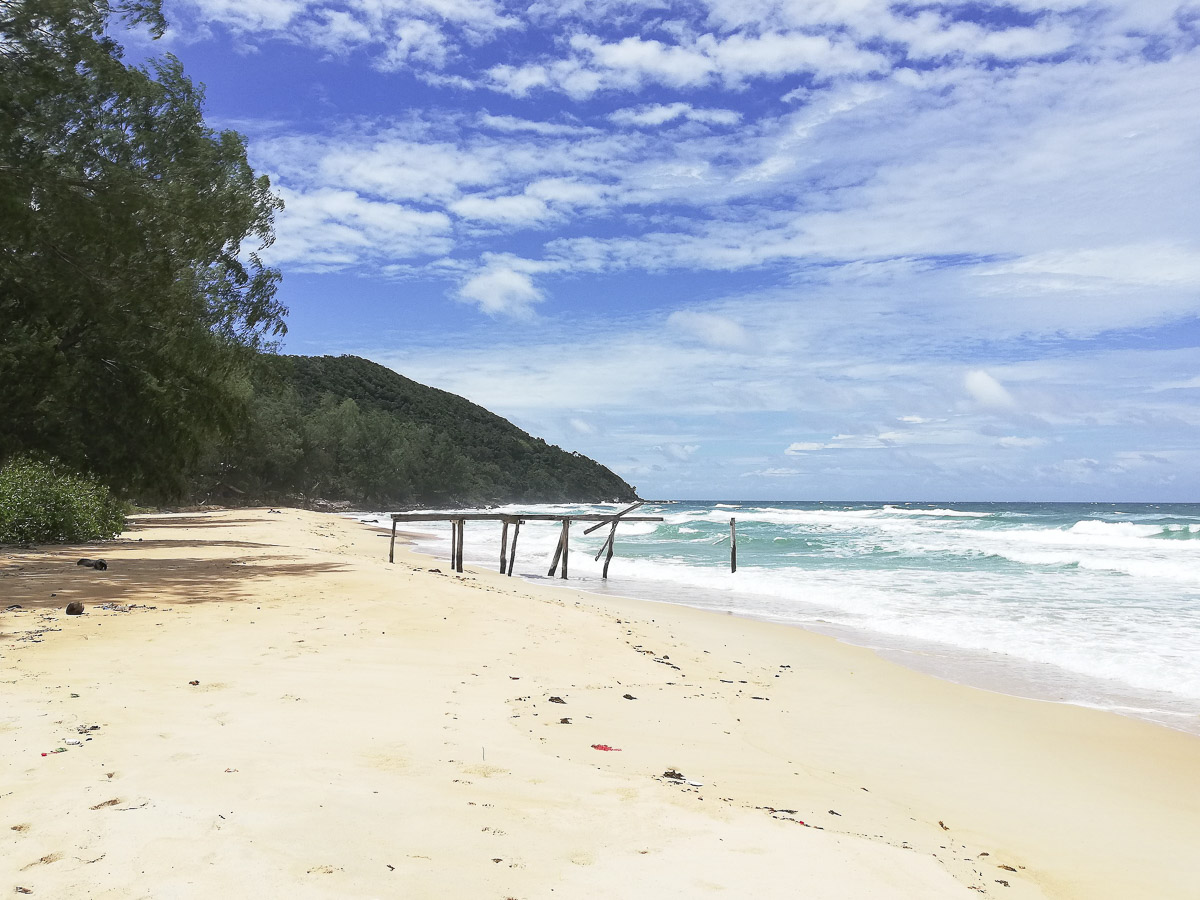 Praia deserta com areia clara e mar agitado em Koh Rong, Camboja.