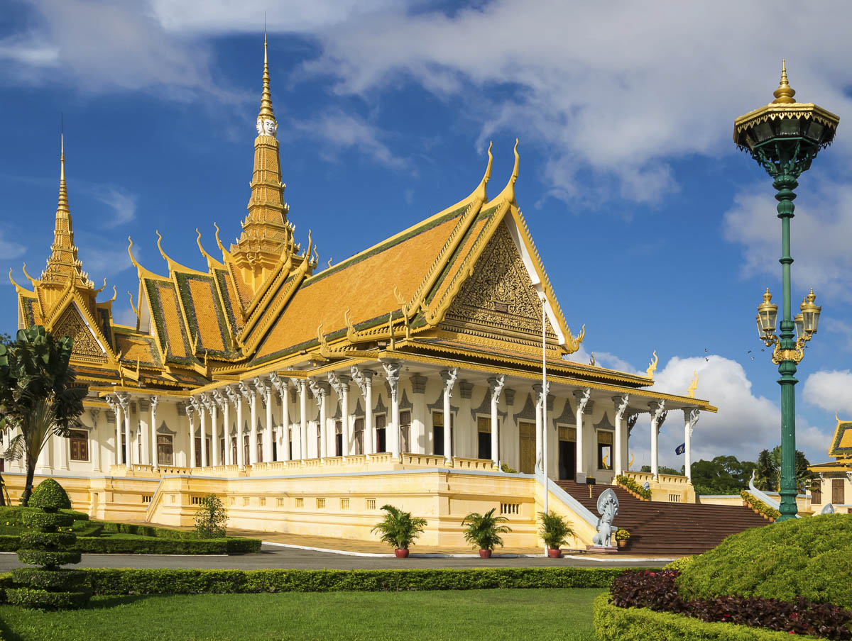 Fachada dourada do Palácio Real de Phnom Penh sob céu azul.