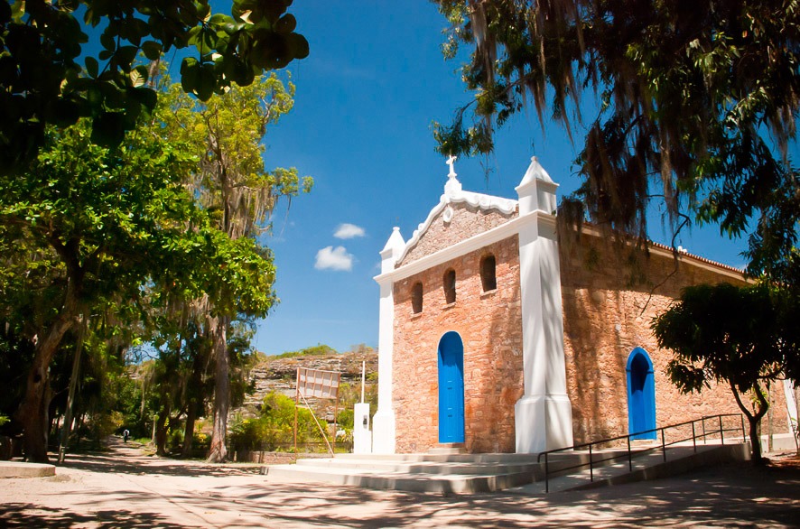 Igreja de São Sebastião em Igatu com fachada de pedra e portas azuis.