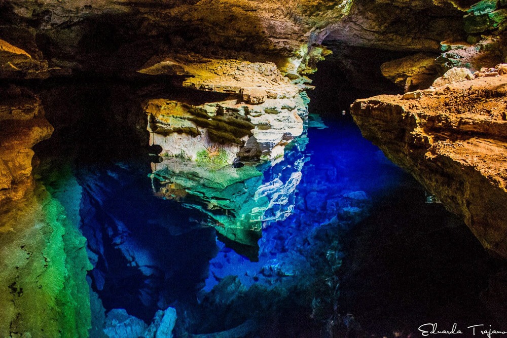 Poço Azul na Chapada Diamantina com água azul brilhante refletindo formações rochosas.