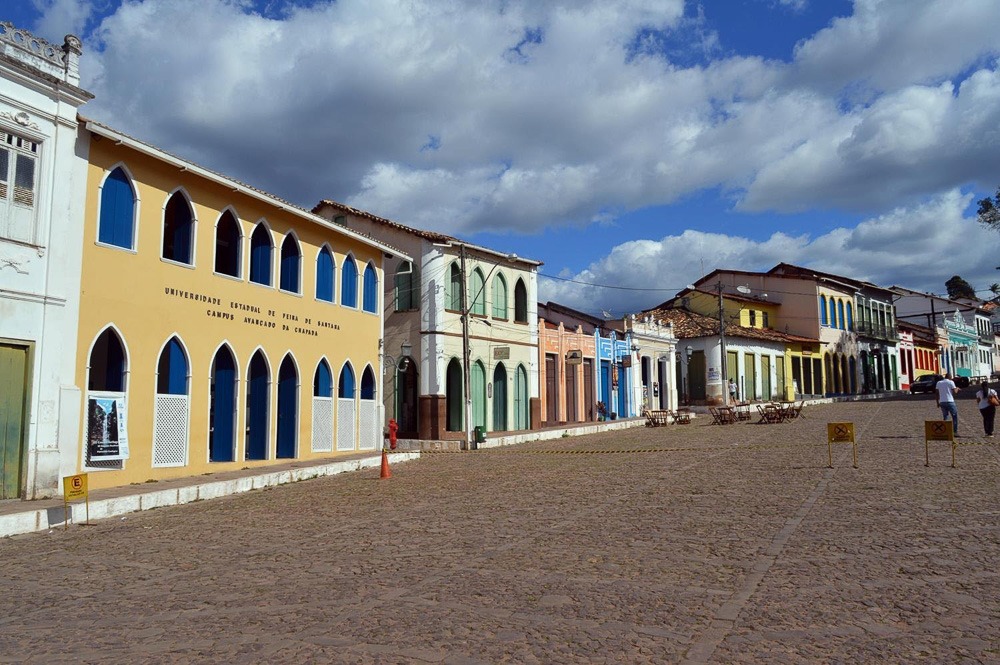 Centro histórico de Lençóis visto da rua de paralelepípedos, com as casas coloridas alinhadas.