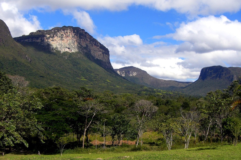 Vale do Capão visto de um mirante, com paredões de pedra, vegetação densa e céu parcialmente nublado.