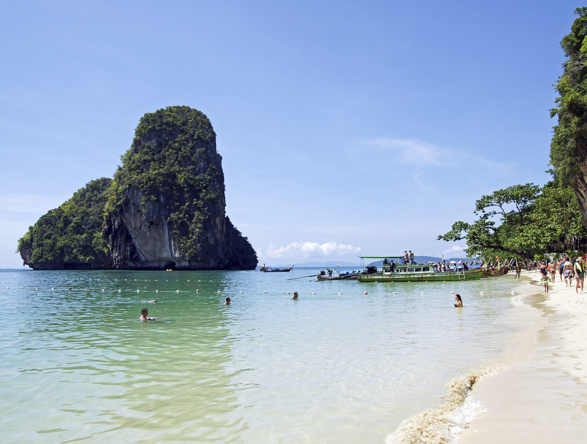 Praia de Phra Nang com falésias cobertas de vegetação e mar azul-claro, em Krabi.