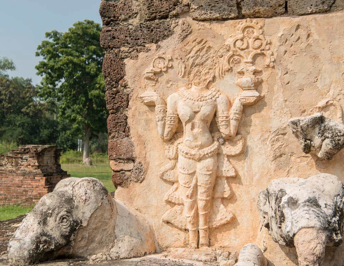 Escultura em relevo de figura feminina com ornamentos no templo Wat Chedi Si Hong, em Sukhothai.