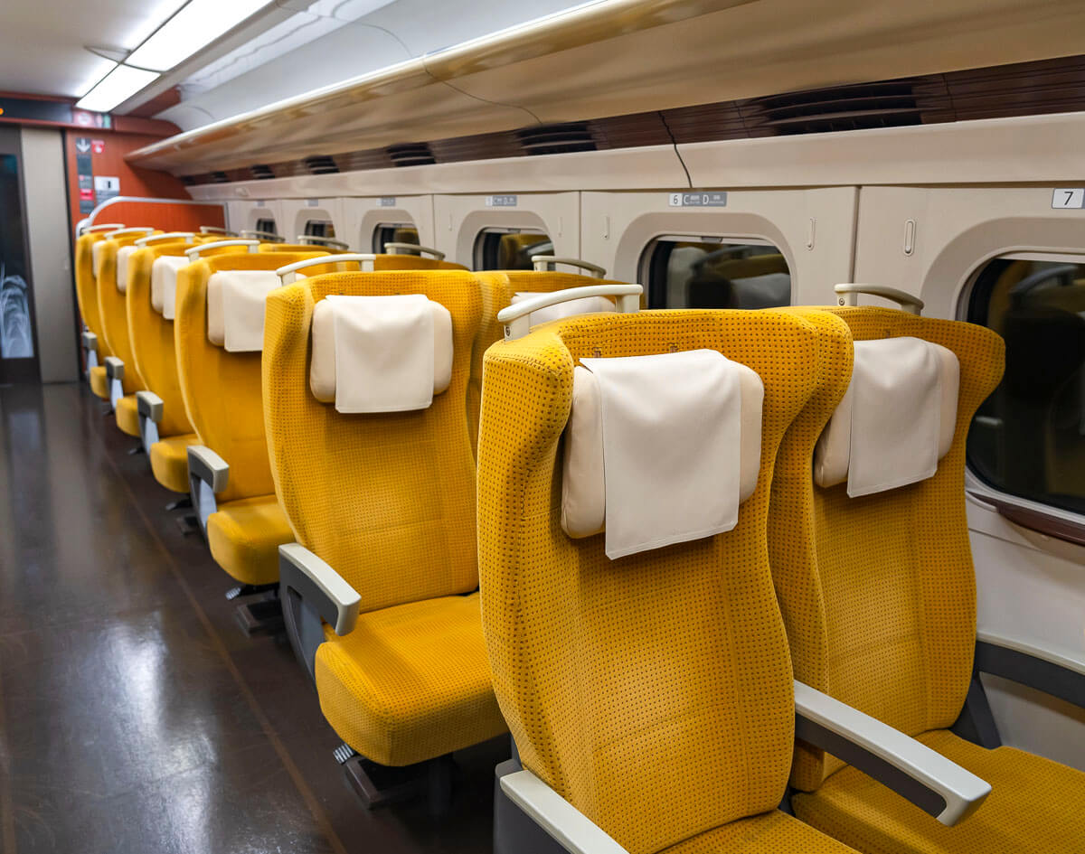 Interior do trem-bala no Japão com fileiras de assentos amarelos