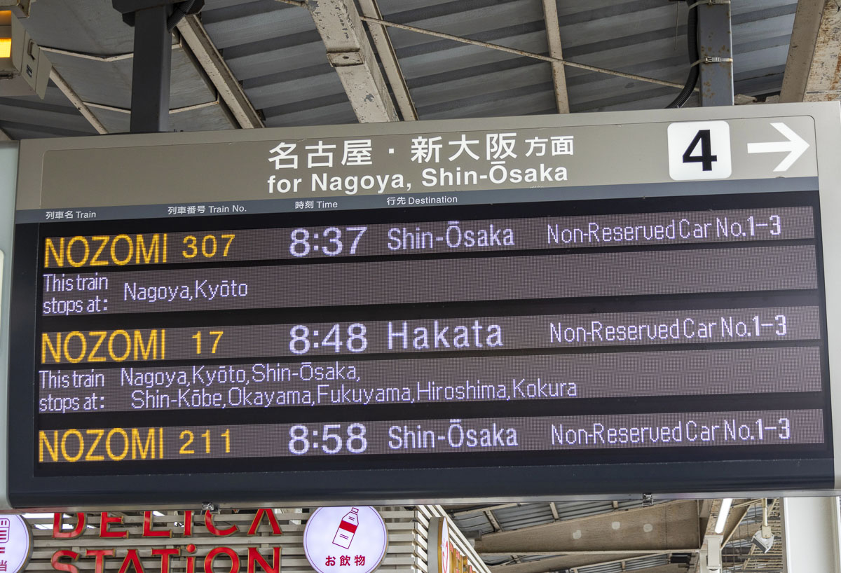 Trem-bala parado na plataforma no Japão com sinalização e piso tátil