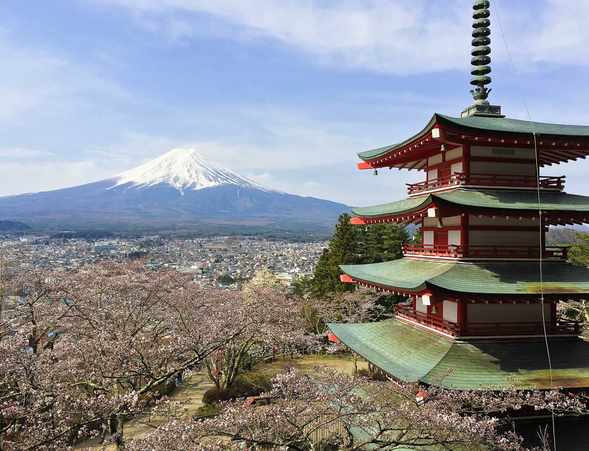 Pagoda vermelha do Arakurayama Sengen Park com o Monte Fuji ao fundo e cerejeiras floridas