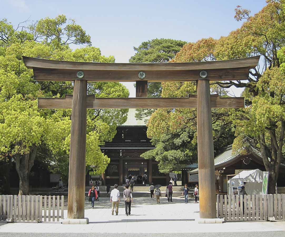 Torii de madeira na entrada do Santuário Meiji Jingu, em Tokyo, cercado por árvores