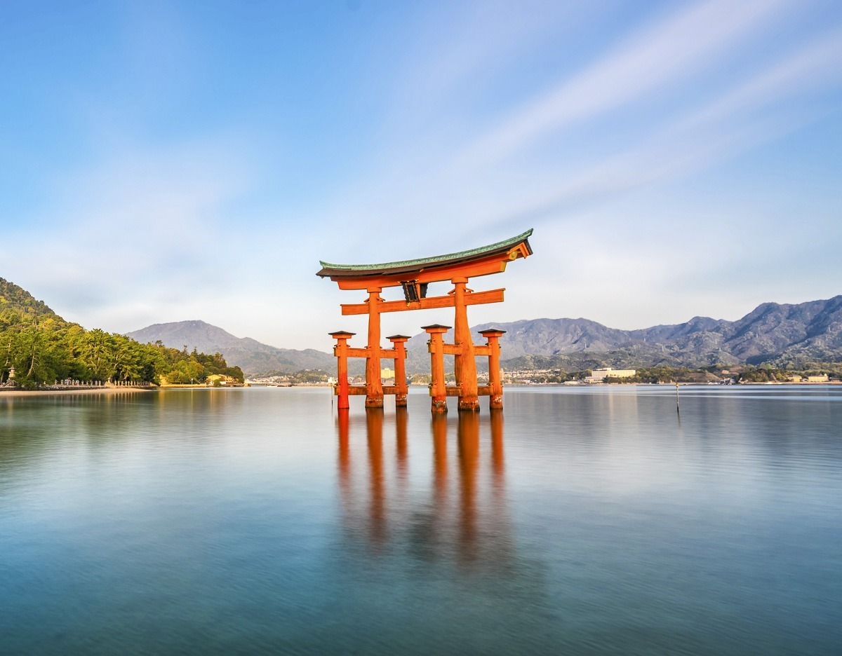 Vista panorâmica da Ilha de Miyajima com torii, construções e vegetação.