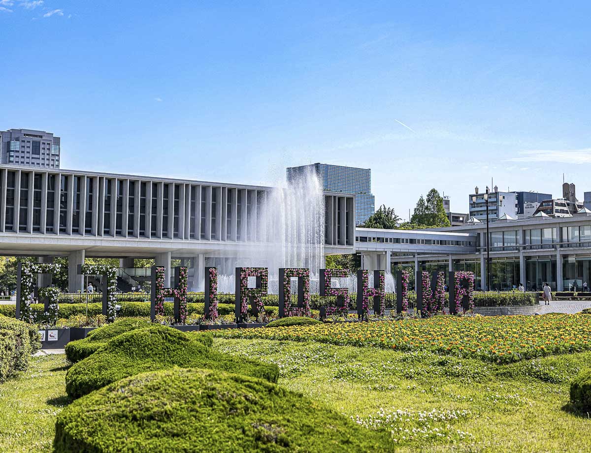 Museu Memorial da Paz de Hiroshima, com jardins e edifício moderno ao fundo.