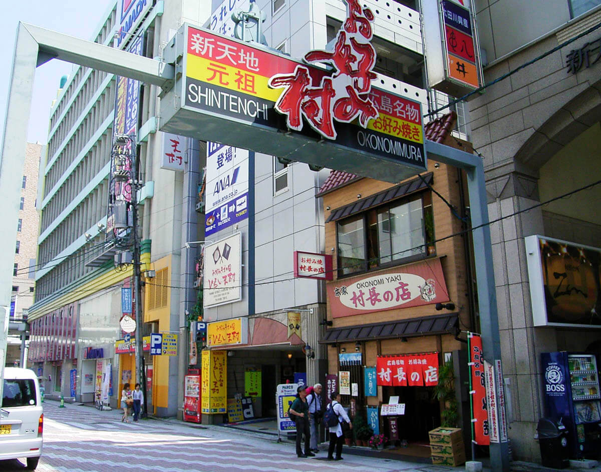 Entrada do Okonomimura em Hiroshima, com placas coloridas e restaurantes de okonomiyaki