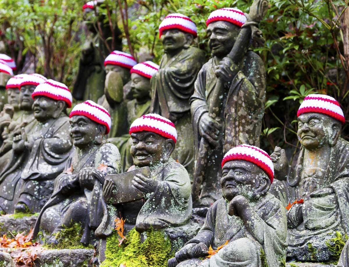 Estátuas de pedra no Templo Daisho-in, em Hiroshima, com gorros vermelhos tradicionais