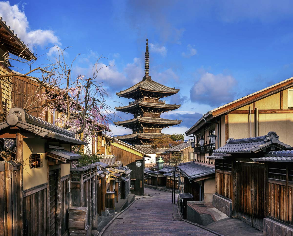 Rua tradicional de Kyoto com casas de madeira e o Templo Hōkan-ji, conhecido como Yasaka Pagoda, ao fundo.