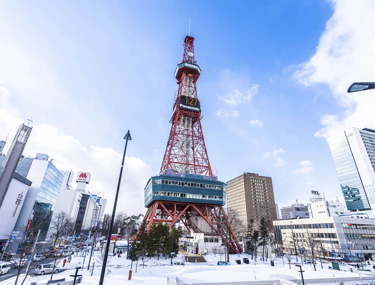 Sapporo TV Tower no inverno, com neve nas ruas e prédios ao redor.
