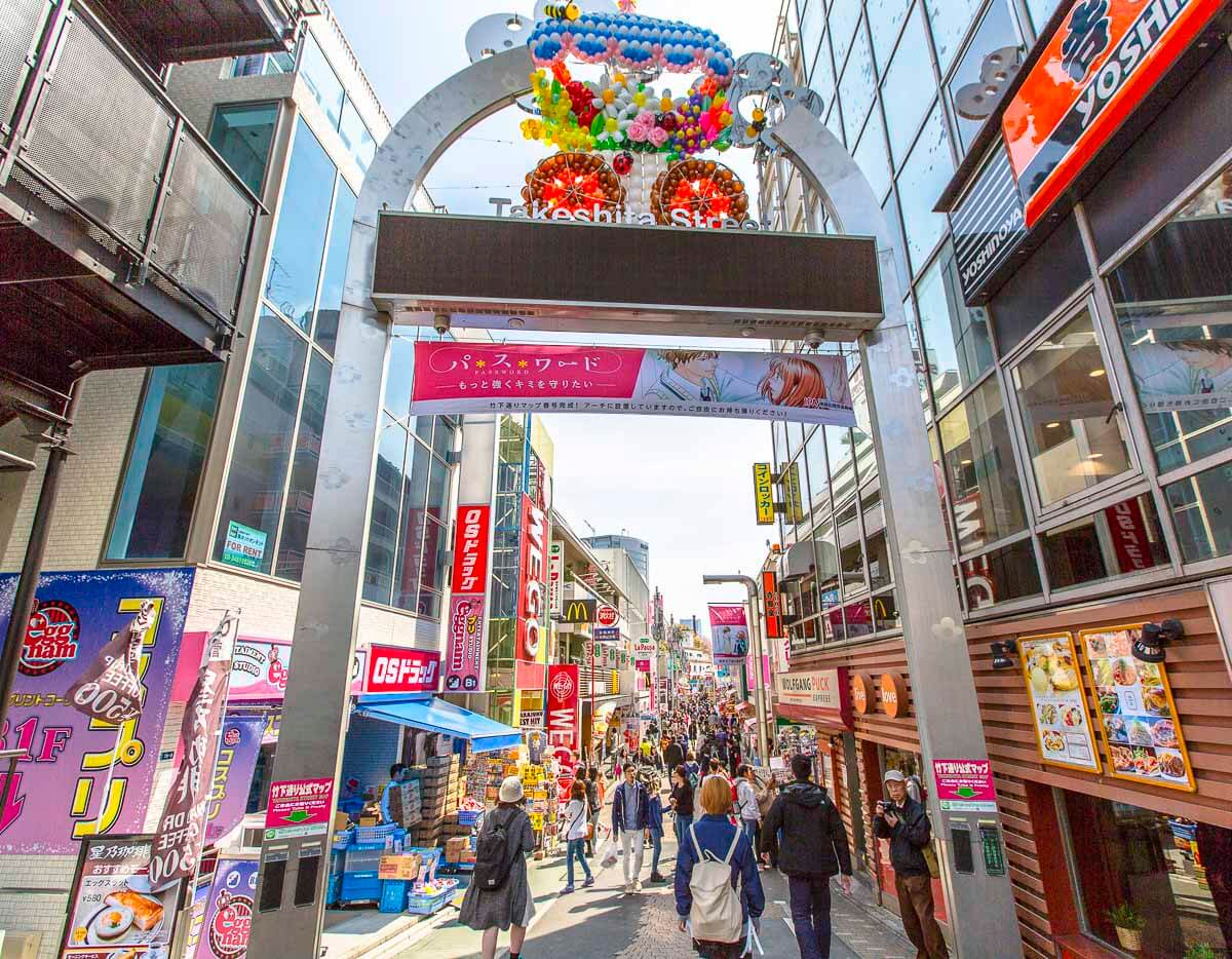 Entrada da Takeshita Street, em Harajuku, com arco decorado e rua cheia de pedestres