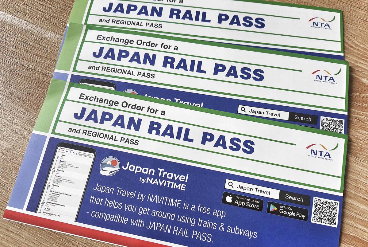 Vouchers do Japan Rail Pass sobre superfície de madeira.