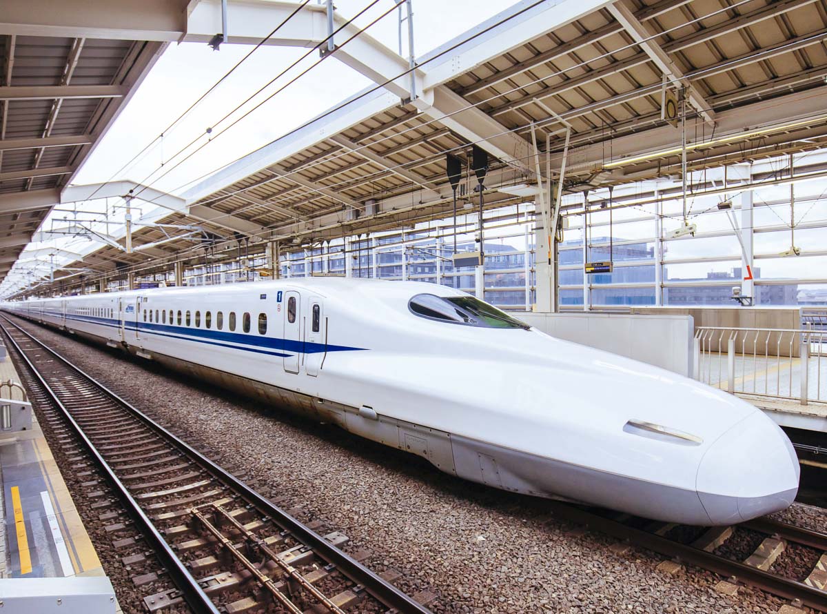 Trem-bala Shinkansen parado em plataforma de estação japonesa.
