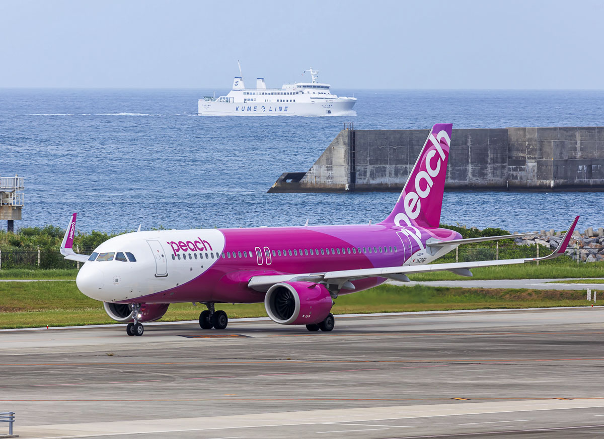 Avião da Peach Aviation taxiando em aeroporto costeiro do Japão.