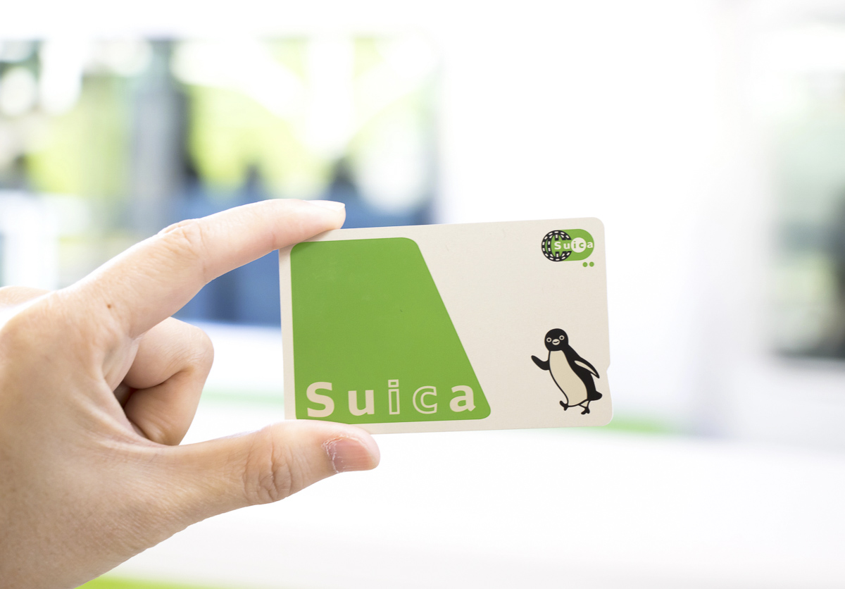 Cartão Suica sendo segurado por uma mão em ambiente claro.