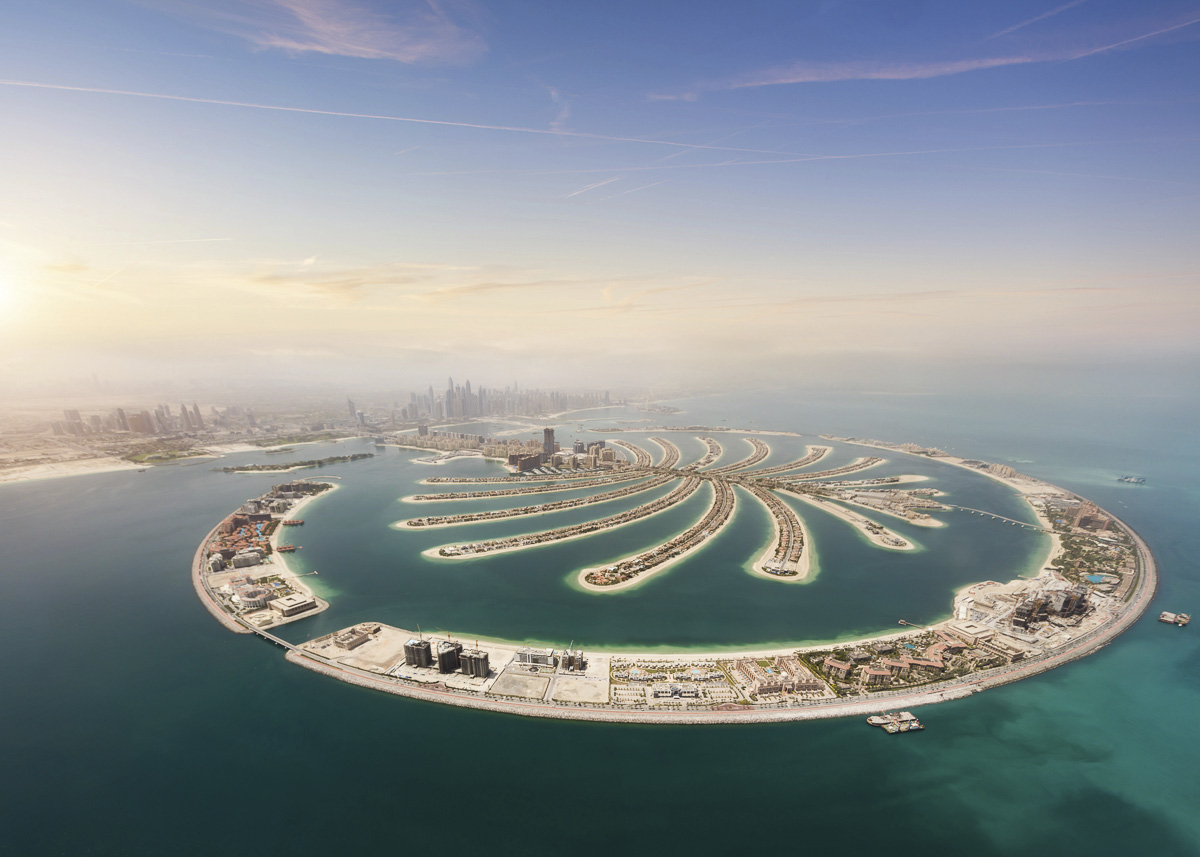 Vista aérea da Palm Jumeirah em Dubai, mostrando o formato de palmeira cercado pelo mar azul.