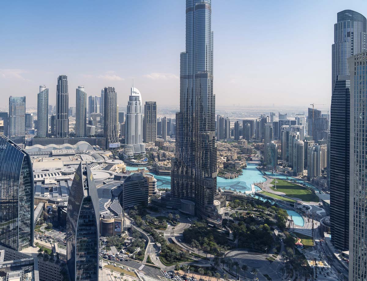 Vista aérea de Dubai a partir do Sky View Observatory, com arranha-céus e lago turquesa ao redor do Burj Khalifa.