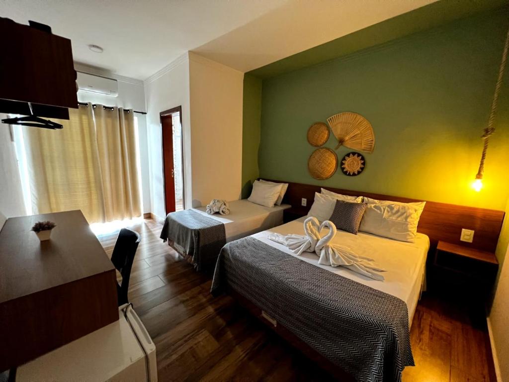 Quarto do Hotel Fazenda Vale da Cachoeira em Serra Negra com cama de casal e cama de solteiro, decoração em tons verdes