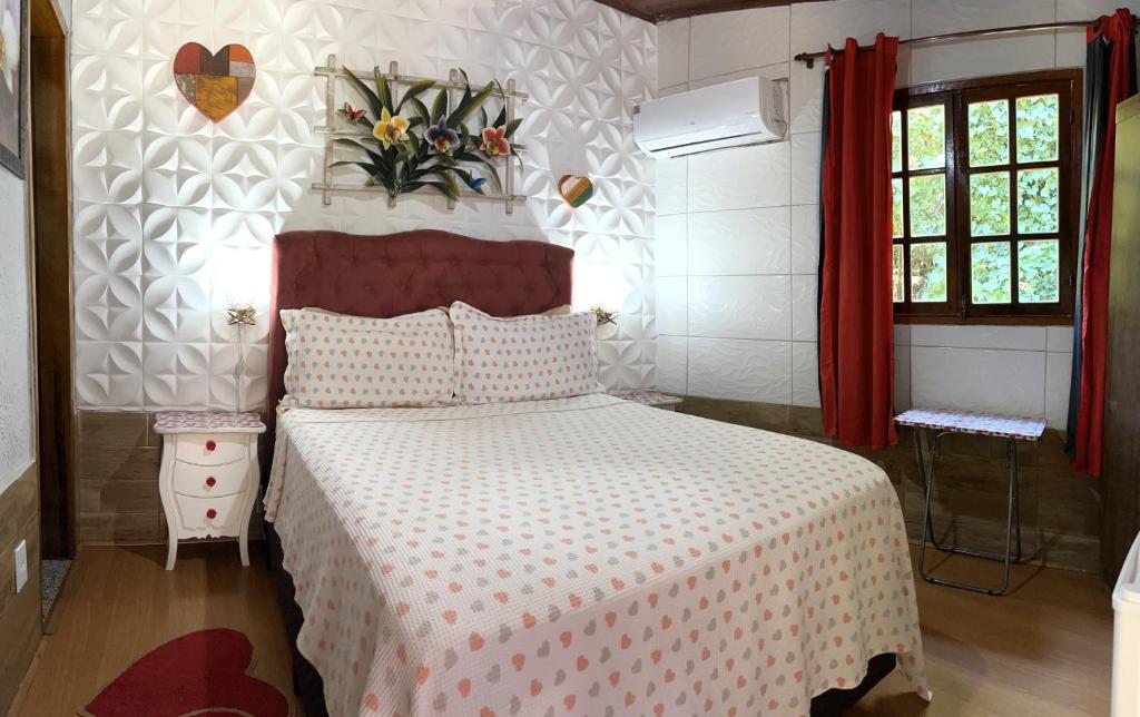 Quarto da Pousada Cascata dos Amores em Teresópolis com cama de casal, cabeceira estofada e decoração romântica