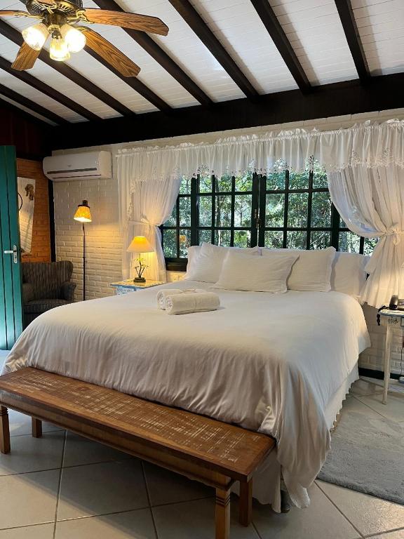 Quarto do Urikana Boutique Hotel em Teresópolis com cama king size, janelas amplas e decoração aconchegante