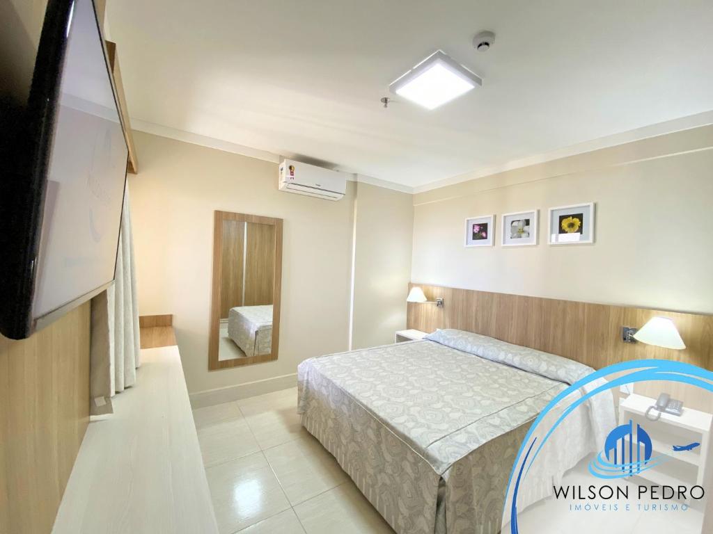Quarto do Piazza DiRoma em Caldas Novas com cama de casal, espelho e ar-condicionado