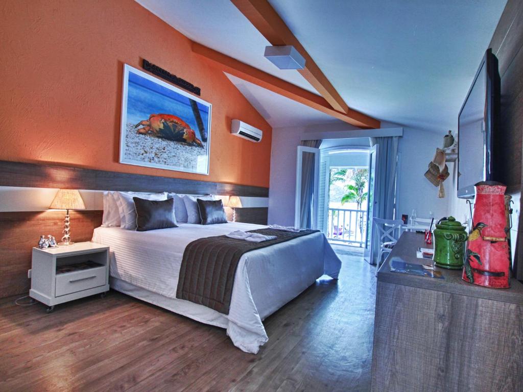 Quarto do Costa Verde Tabatinga Hotel em Caraguatatuba com cama de casal e varanda com vista para o mar