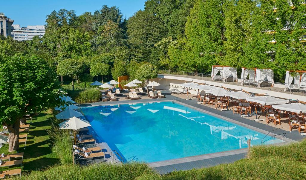 Piscina do InterContinental Genève ao ar livre com espreguiçadeiras e área verde