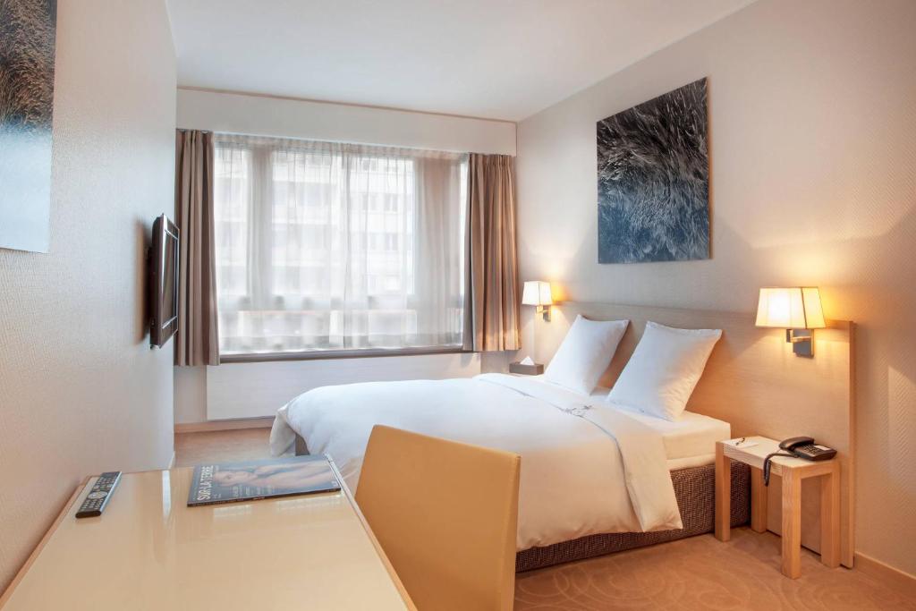 Quarto do Starling Hotel Residence Genève com cama de casal e janela grande