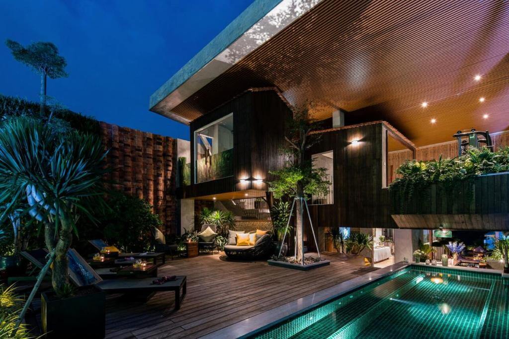 Área externa do Au Lac Legend Hotel em Ho Chi Minh com piscina iluminada e deck de madeira