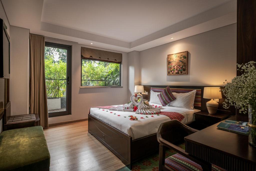 Quarto do Au Lac Legend Hotel em Ho Chi Minh com cama de casal decorada e varanda