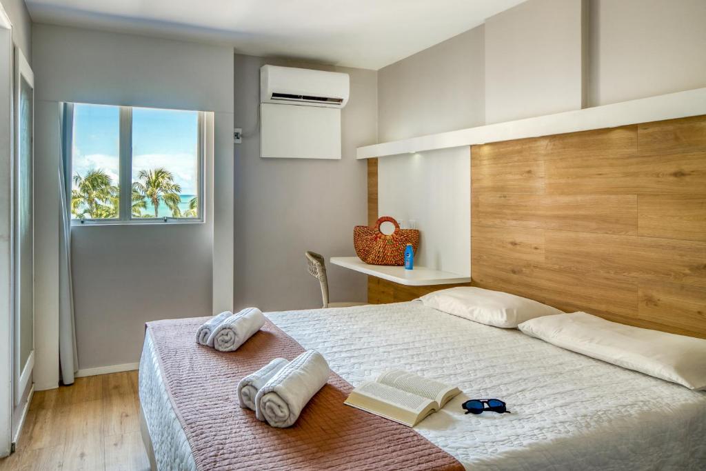Quarto do Hotel Costamar Ponta Verde em Maceió com cama de casal, janela com vista para o mar e decoração simples