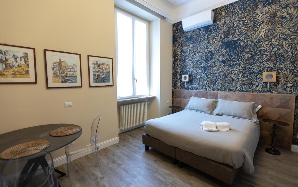 Quarto do Household Settembrini em Milão com cama de casal, mesa redonda e parede decorada