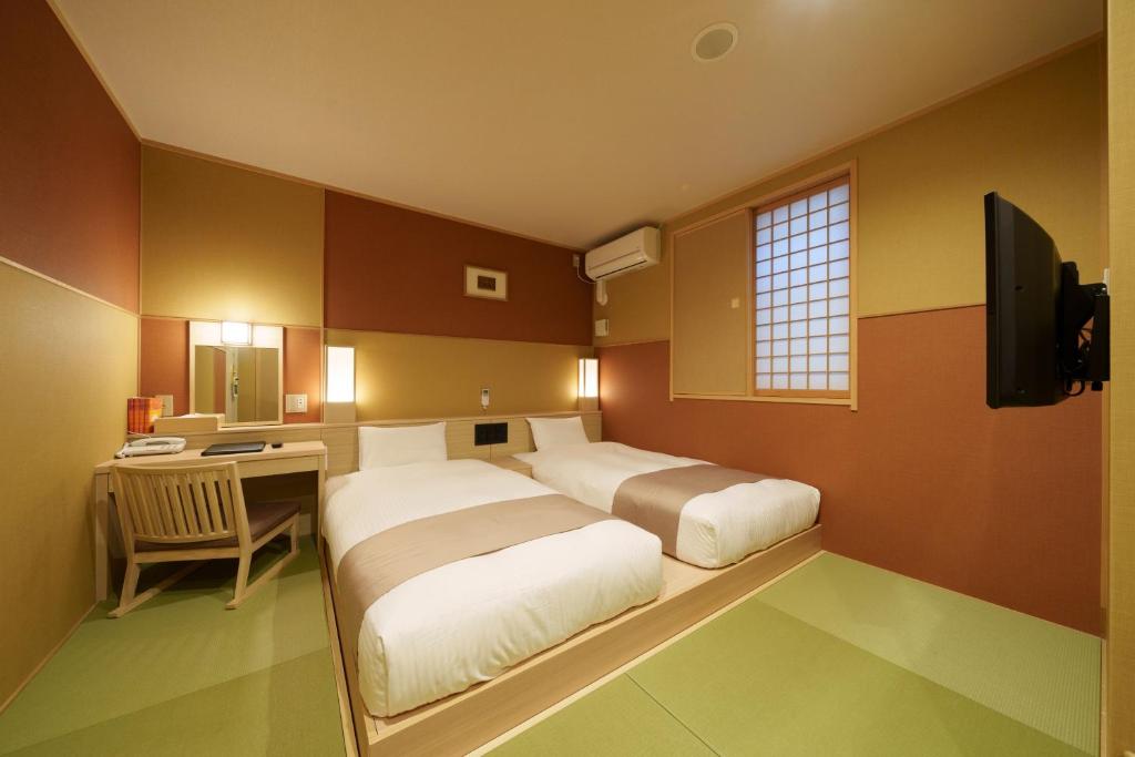 Quarto do Waqoo Shitaderamachi em Osaka com duas camas de solteiro sobre tatame e decoração japonesa
