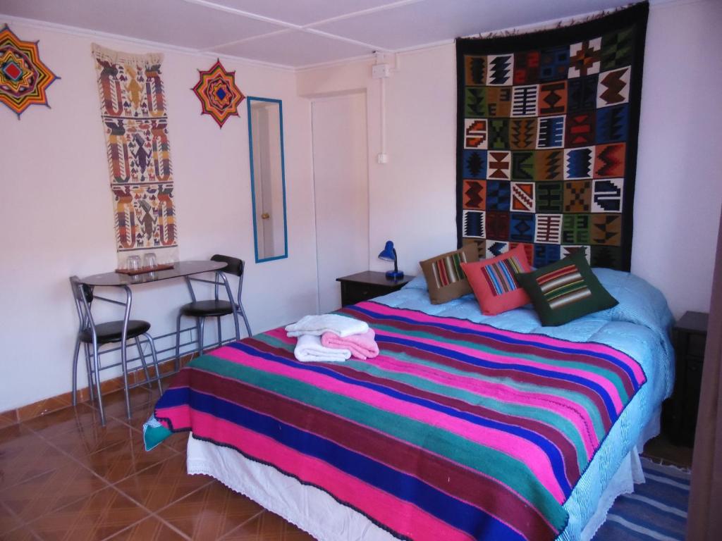 Quarto do Hostal Campo Base no Atacama com cama de casal e decoração colorida